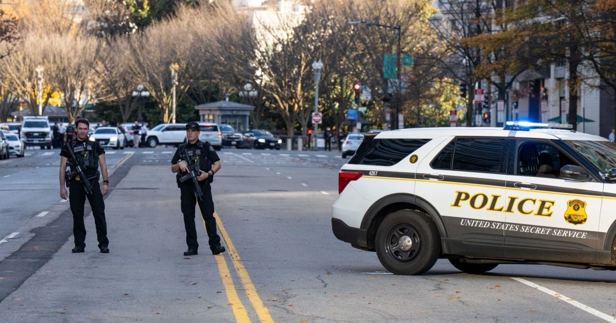 Doi ofițeri de poliție înarmați blochează o stradă care duce spre complexul Casei Albe, Washington DC, SUA, noiembrie 2025