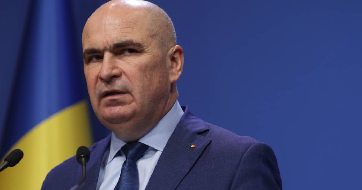 Ilie Bolojan în timpul unei conferințe de presă, se uită încruntat înspre camerele foto