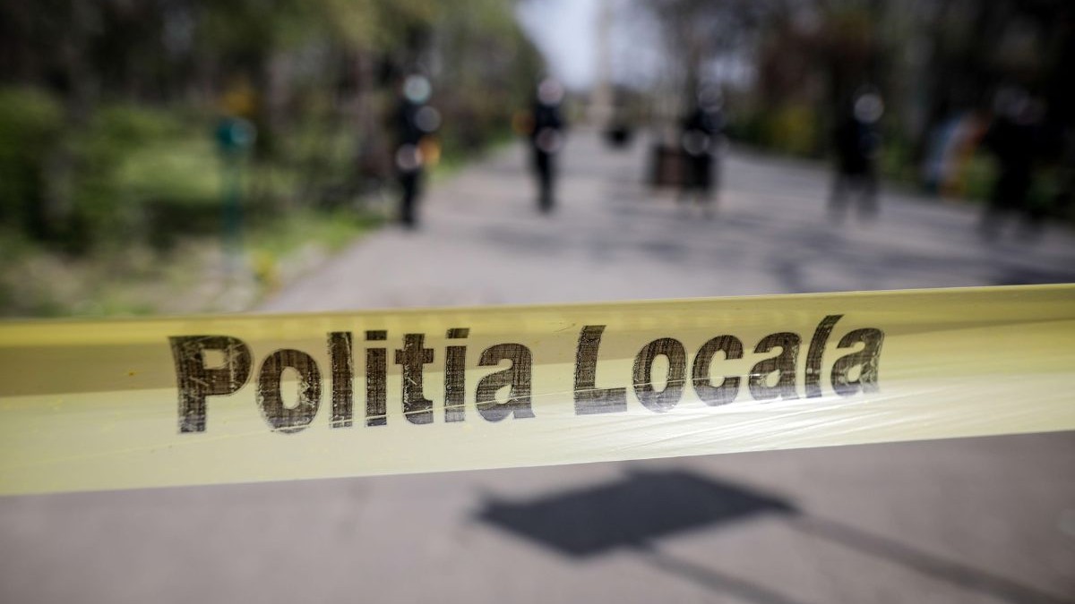 banderolă galbenă cu textul „Poliția locală” prinsă în capătul unei străzi pietruite