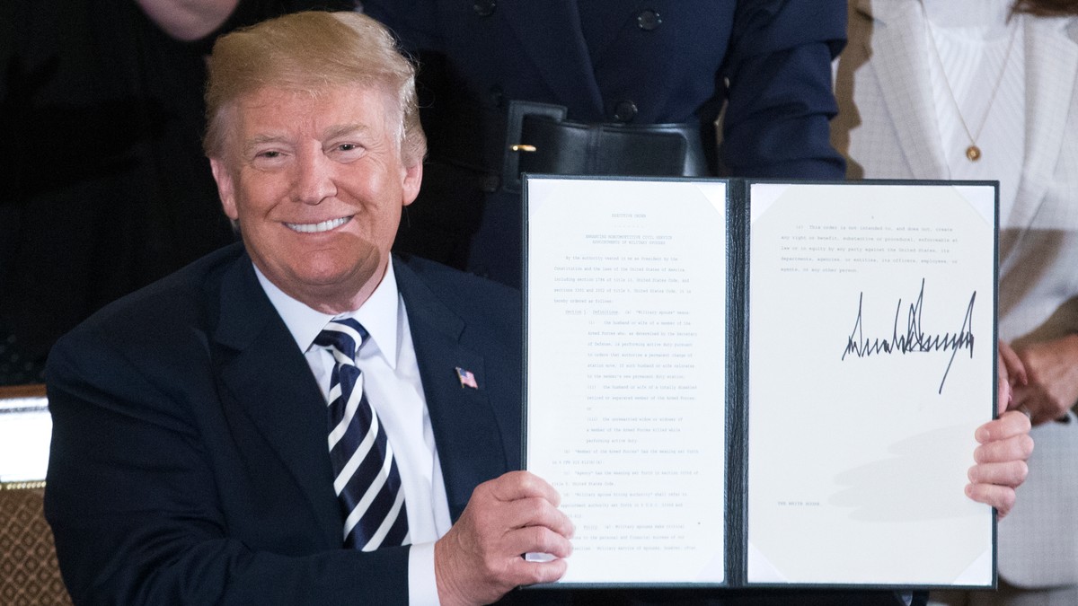 Președintele SUA, Donald J. Trump, ține în mână un decret prezidențial semnat privind oportunitățile de angajare la nivel federal pentru soții și soțiile personalului militar, pe care tocmai l-a semnat în cadrul unei ceremonii desfășurate în Sala de Est a Casei Albe din Washington, DC, SUA, la 9 martie 2018.