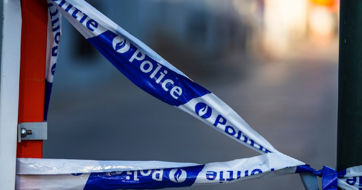 Bruxelles Belgia 2025-07-11 Detaliu cu o bandă adezivă de tip barieră a poliției belgiene albastre și albe, cu cuvintele „Politie” și „Police” imprimate pe ea, legate între un stâlp de metal și o barieră.