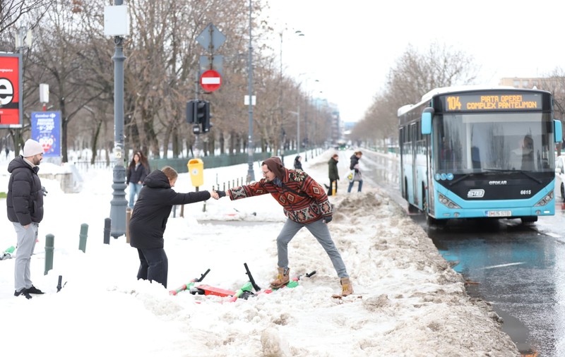 Trotuarele din București, blocate de nămeți și bălți. Oamenii fac slalom printre troiene