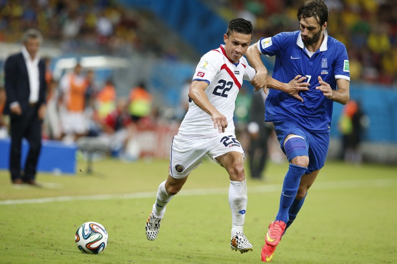 epa04290678 Jose Cubero of Costa Rica (L) and Georgios Samaras of Greece in action during the FIFA World Cup 2014 round of 16 match between Costa Rica and Greece at the Arena Pernambuco in Recife, Brazil, 29 June 2014. (RESTRICTIONS APPLY: Editorial Use Only, not used in association with any commercial entity - Images must not be used in any form of alert service or push service of any kind including via mobile alert services, downloads to mobile devices or MMS messaging - Images must appear as still images and must not emulate match action video footage - No alteration is made to, and no text or image is superimposed over, any published image which: (a) intentionally obscures or removes a sponsor identification image; or (b) adds or overlays the commercial identification of any third party which is not officially associated with the FIFA World Cup) EPA/JEON HEON-KYUN EDITORIAL USE ONLY