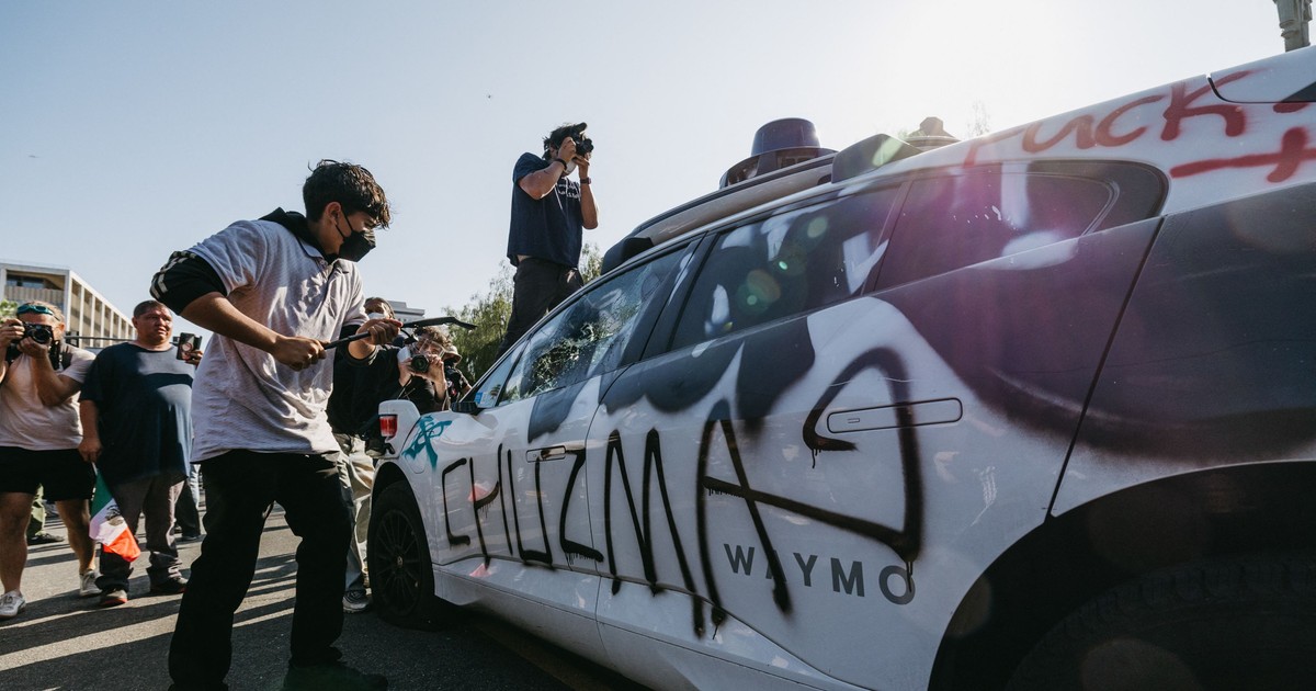 Protestatar surprins în timp ce atacă o mașină în timpul demonstrațiilor din Los Angeles, pe 8 iunie 2025
