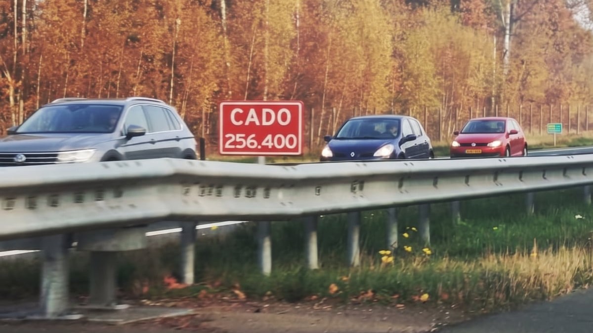 O autostradă pe care circulă mașini. Se observă un indicator roșu pe care scrie CADO