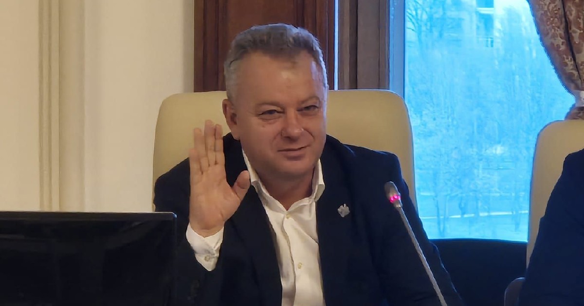 Ion Iordache, deputat PNL ține mâna dreaptă sus, în fața sa fiind un microfon