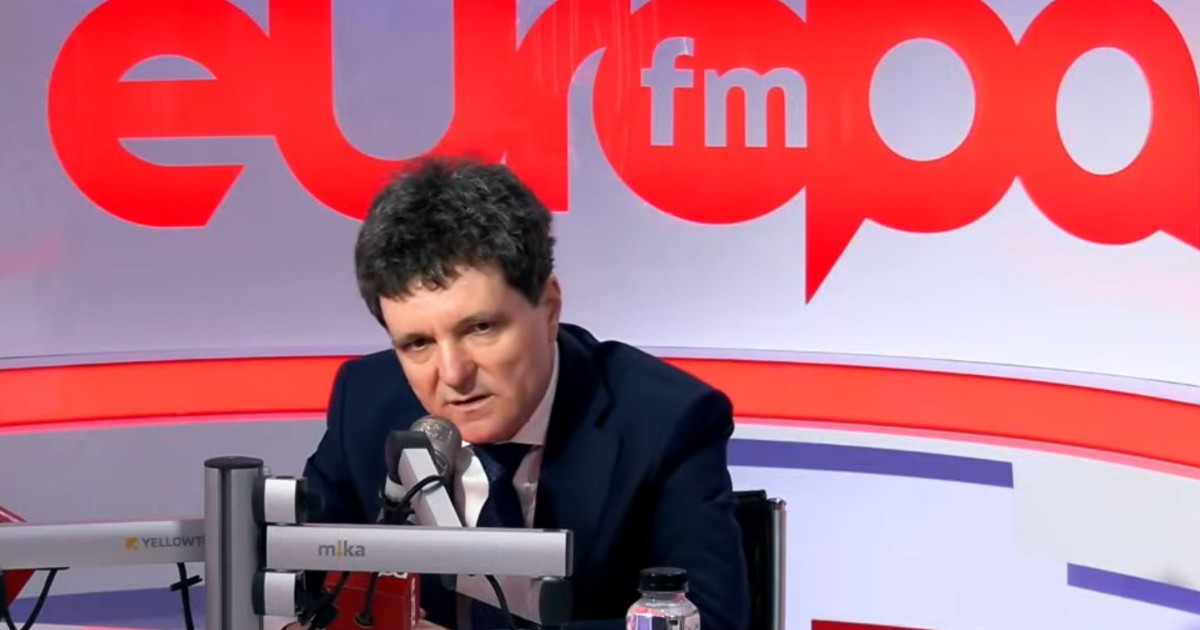 Președintele Nicușor Dan, invitat în platoul Europa FM, în timpul emisiunii pe care Realitatea Plus ar fi preluat-o ilegal. Președintele este îmbrăcat la costum, stă la masă și vorbește în fața microfonului.