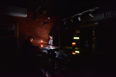 Un bărbat cumpără alimente dintr-un magazin, la lumina lumânărilor, după un atac asupra Liovului. Pe 15 noiembrie, Rusia a lansat un atac masiv cu rachete asupra Ucrainei. Liovul a rămas fără energie electrică, apă, căldură și servicii de comunicații mobile din cauza rachetelor care au lovit instalațiile energetice. | Foto: Profimedia