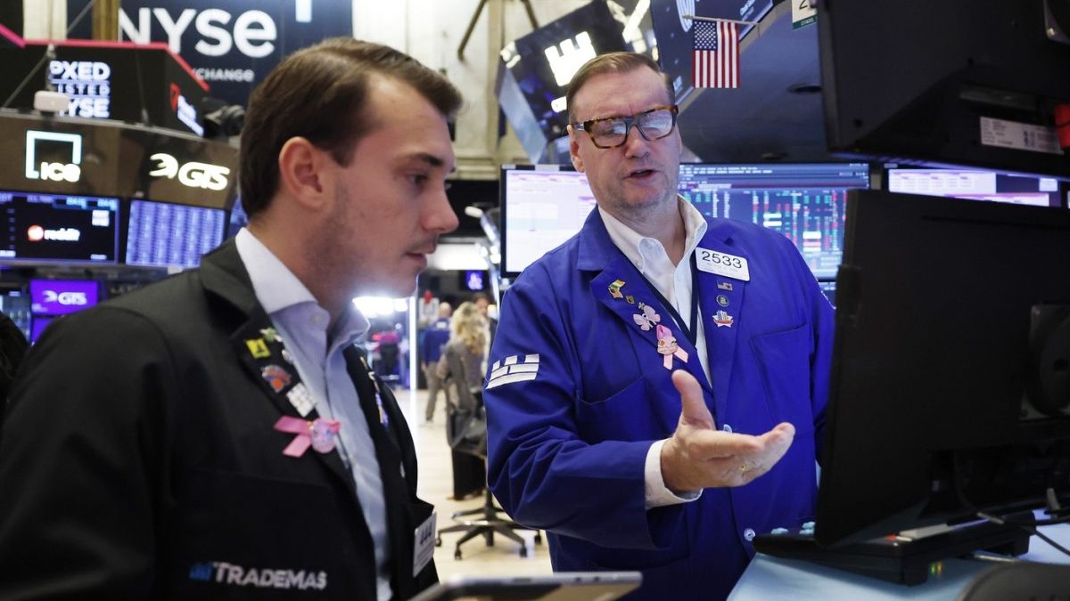 Traderi lucrează pe ringul Bursei de Valori din New York de pe Wall Street, vineri, 10 octombrie 2025