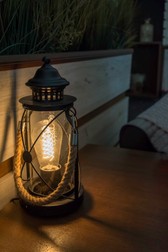 Electric lantern in a bar table with rope handle. shadow and light