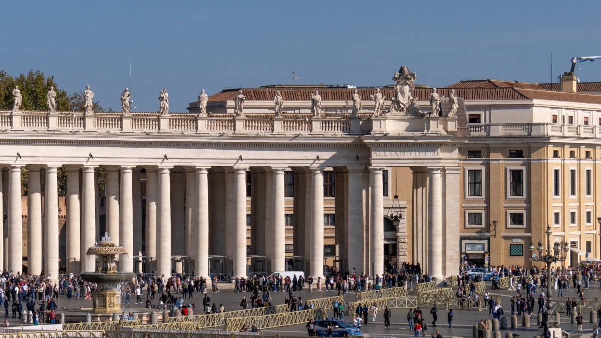 În imagine este ilustrată Piața Sf. Petru din Roma, cu oameni în jurul său
