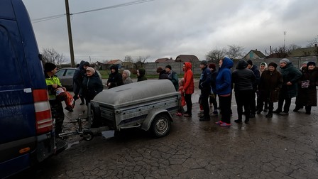 Coada de oameni care îl așteaptă pe Petru, cu ajutoare, în zona Herson
