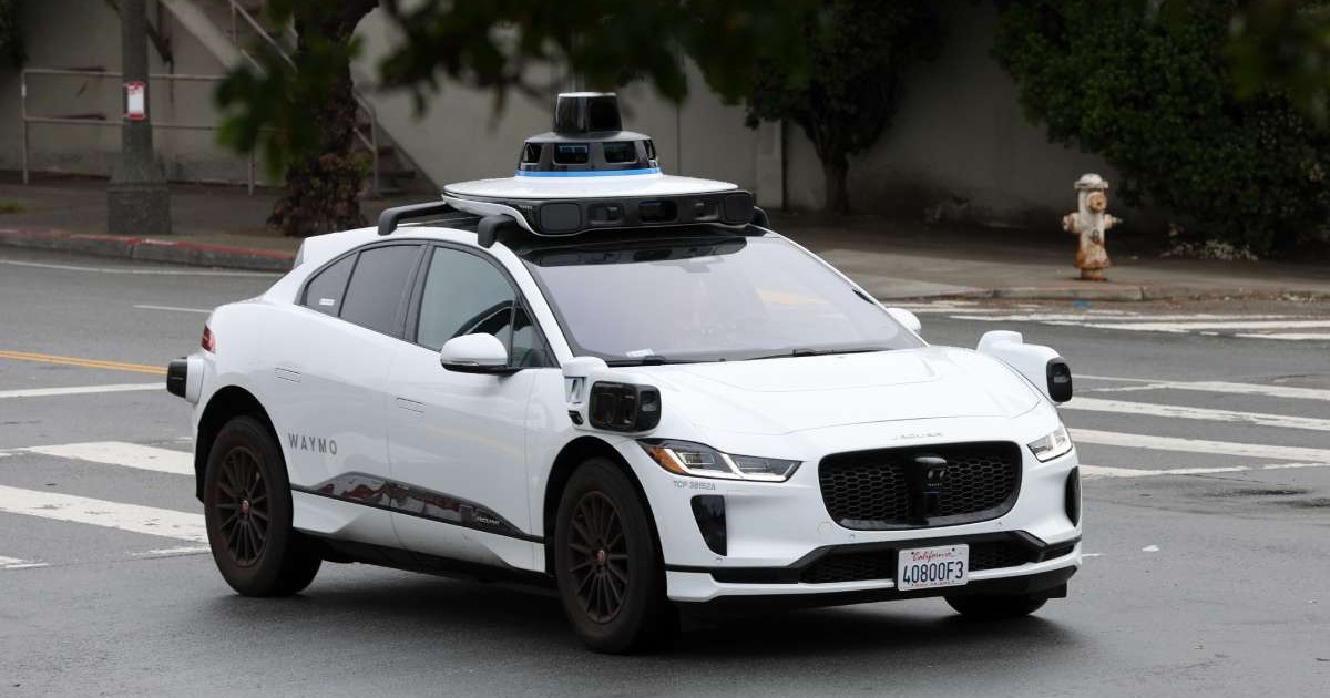 Un taxi-robot Waymo, de tip Jaguar E-Pace Alb, pe o stradă din San Francisco.