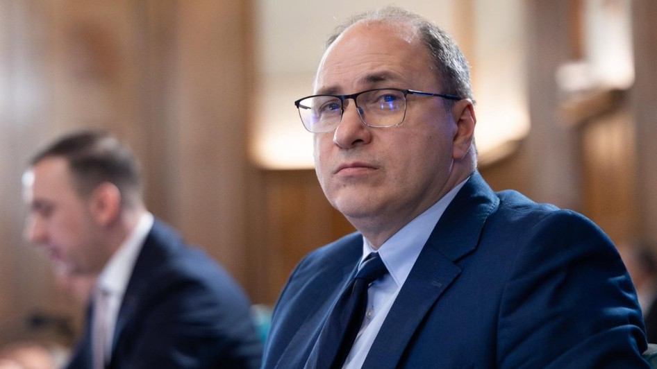 Mihai Dimian, ministrul interimar al Educatiei, în Guvernul României. Poartă un costum albastru și o pereche de ochelari