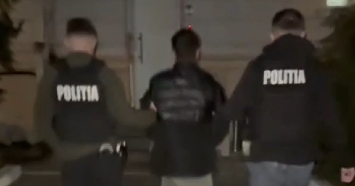 Doi polițiști care duc un tânăr la secție, în timpul nopții