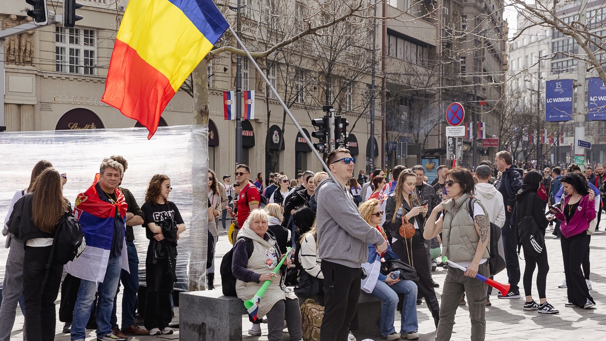 Mai mulți protestari la protestul din Belgrad, Serbia, pe 15 martie. Unul dintre aceștia țin steagul României.