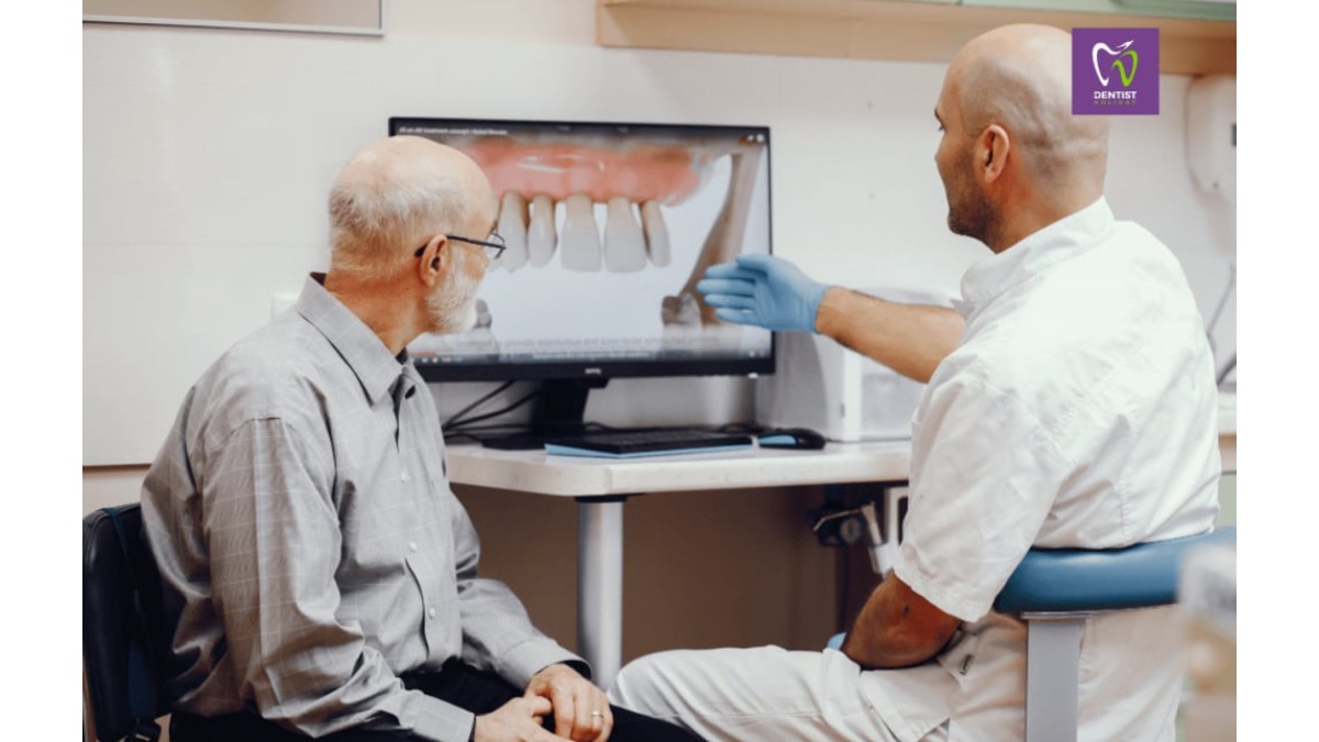 Barbat in varsta la dentist. Domnul doctor ii arata ceva pacientului pe laptop la o ecografie dentara
