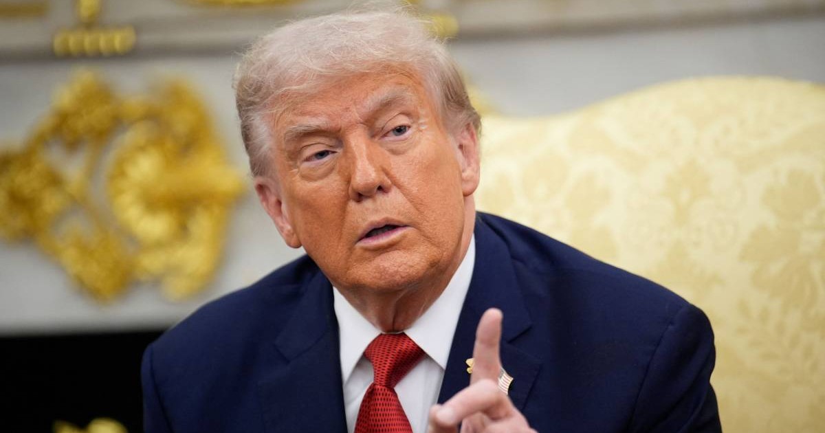 Președintele american Donald Trump stând pe canapeaua galbenă din Biroul Oval, ține degetul arătător ridicat și explică ceva