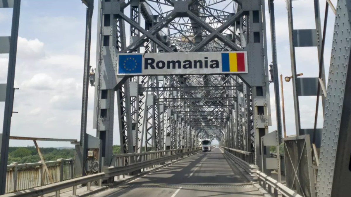 Podul Giurgiu-Ruse, un pod metalic cu o structură de oțel, pe care se află un semn cu inscripția „Romania” alături de steagul Uniunii Europene și steagul României