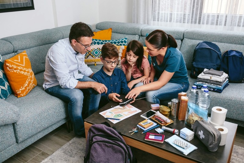 Mother explaining to her children how to use the radio while preparing emergency backpacks