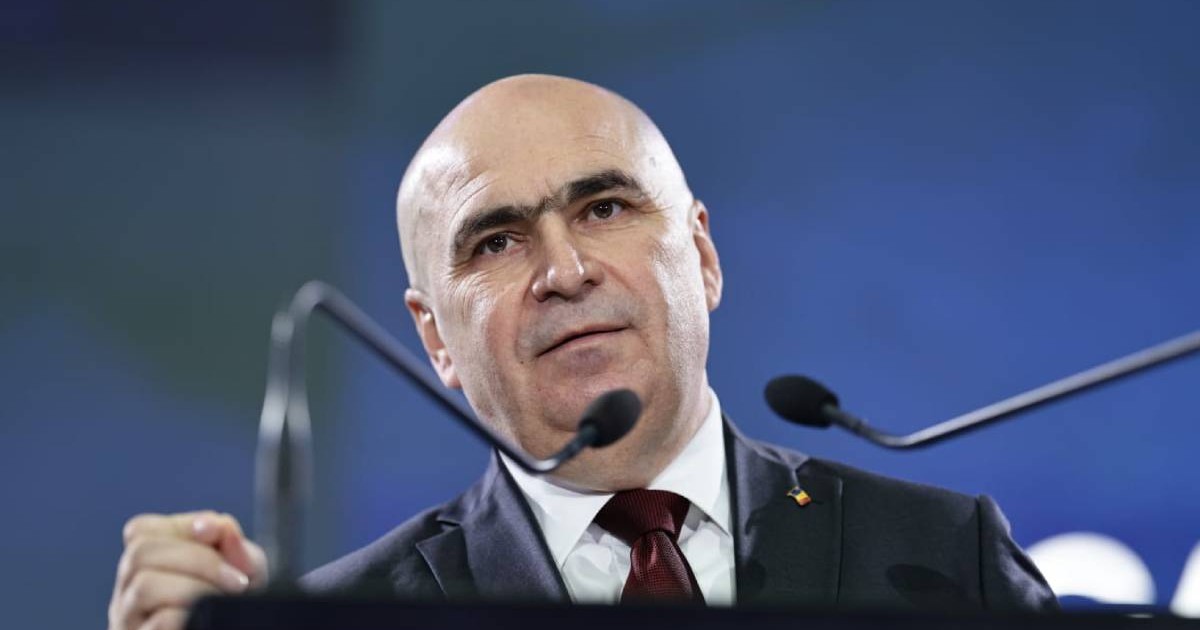 Ilie Bolojan, in sacou negru, cravată, si camasa albă, vorbește la un pupitru cu doua microfoane în față, la Congresul PNL, în timpul discursului ținut înainte de începerea votului