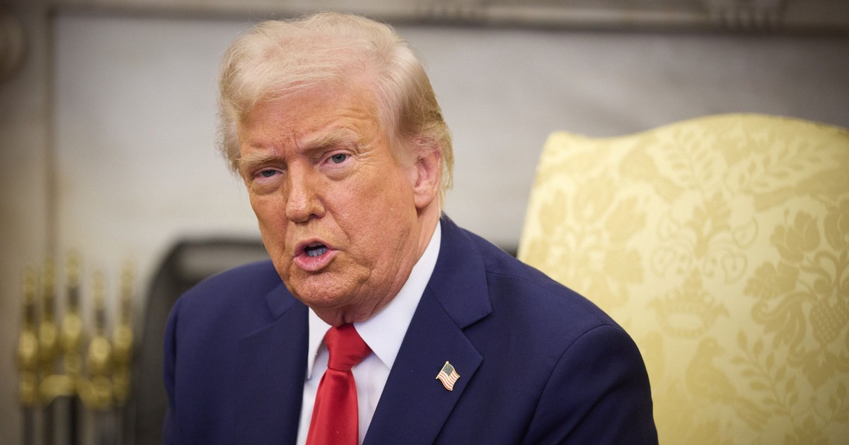 Președintele SUA Donald Trump stând pe scaun, purtând un sacou albastru, cu o cravată roșie și o cămașă albă