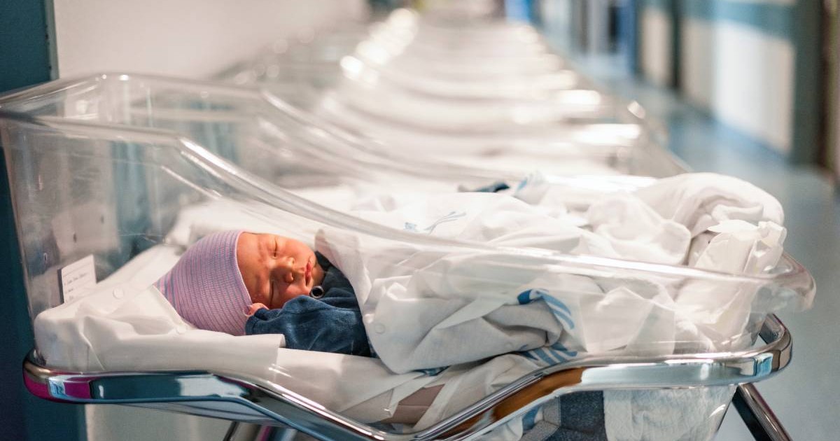 Un bebelus care doarme in spital, intr-o sectie de neonatologie, in pătuț de nou-născuți se vad mai multe păruturi in spate