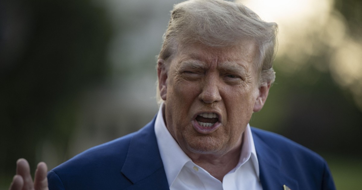 Donald Trump, îmbrăcat în costum albastru închis și cămașă albă