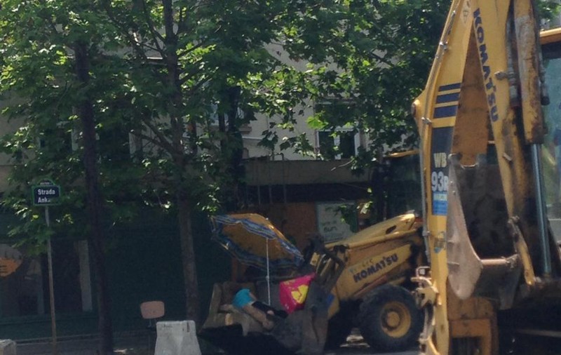 FOTO INCREDIBIL! ÎN LOC să MUNCEASCĂ, DOREL şi-a PUS UMBRELUŢĂ şi DOARME ÎN CUPA EXCAVATORULUI, de se CUTREMURĂ BULEVARDUL!