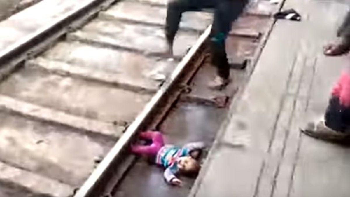 Momentul șocant în care un tren trece peste un bebeluș scăpat pe șine, iar copilul scapă miraculos