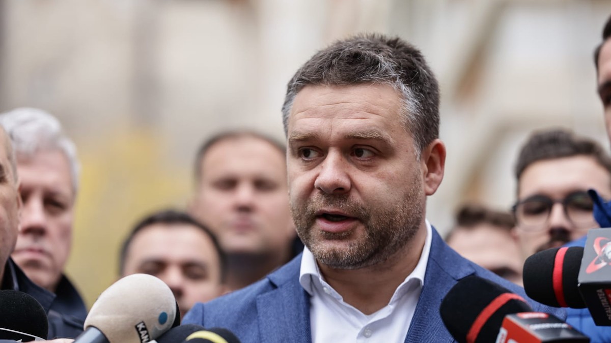 Ciprian Ciucu, cu un sacou albastru si camasa alba, cu un dosar albastru in mana, la depunerea candidaturii pentru Primăria Capitalei
