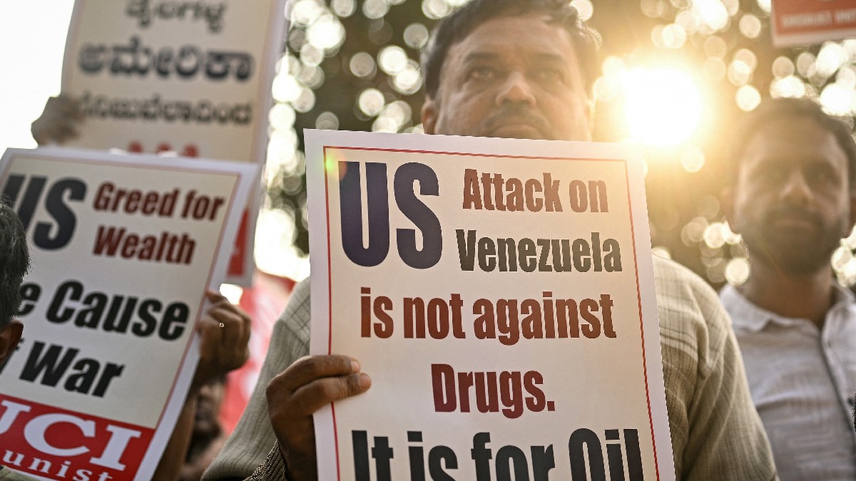 Un activist al Centrului Unității Socialiste din India ține o pancartă în timp ce participă la o demonstrație împotriva atacului SUA asupra Venezuelei, în Parcul Libertății din Bengaluru, pe 4 ianuarie 2026.