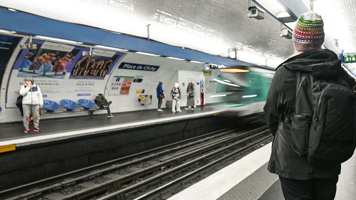 Un tren de metro sosește într-o stație și pe peron sunt mai mulți călători