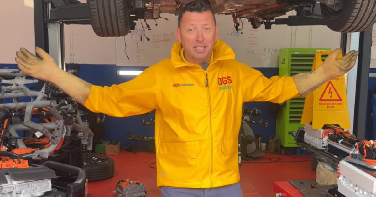 Un bărbat care are o geacă galbenă și se află într-un service auto.
