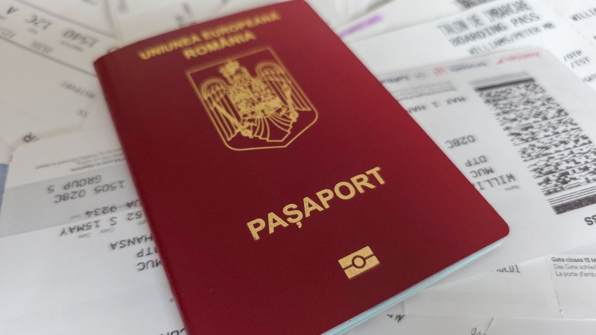 Pașaport românesc, de culoare maro, peste multe cărți de îmbarcare