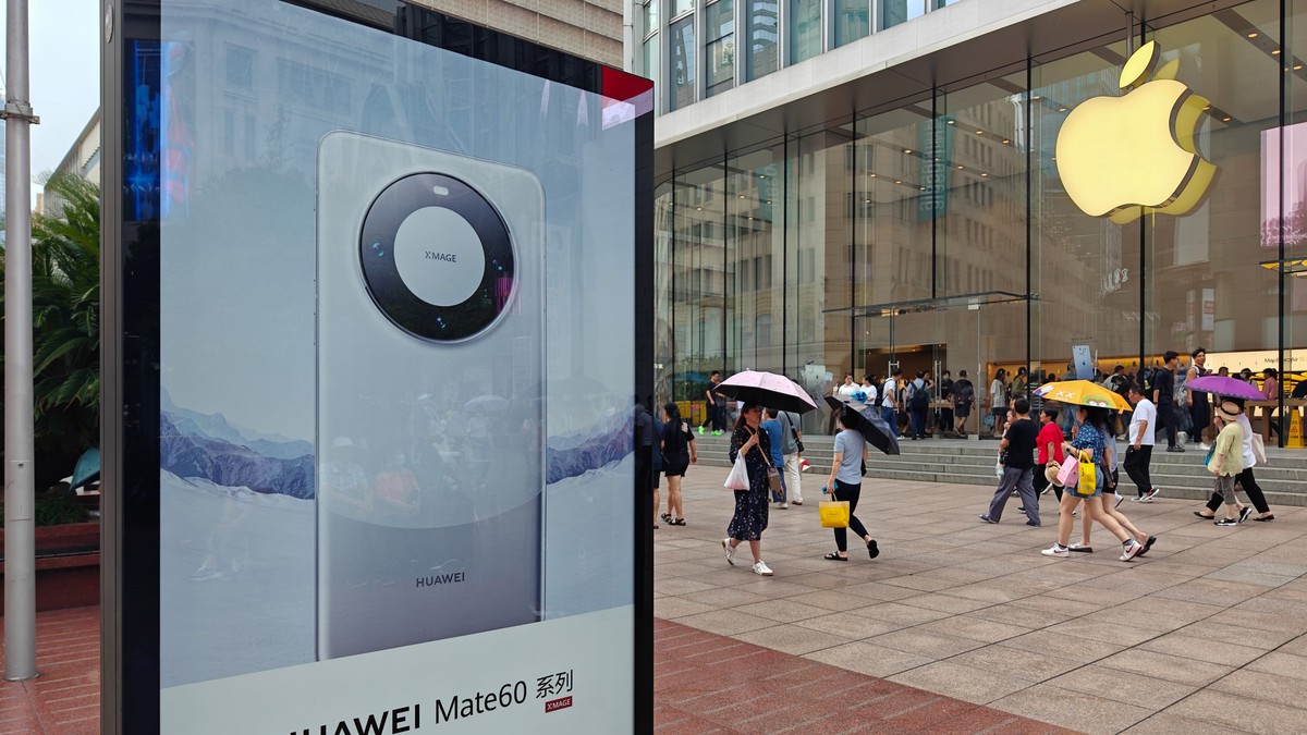 SHANGHAI, CHINA - SEPTEMBER 13, 2023 - A light box advertising Huawei Mate 60 mobile phone is seen in front of the Apple store on Nanjing Road in Shanghai, China, September 13, 2023.