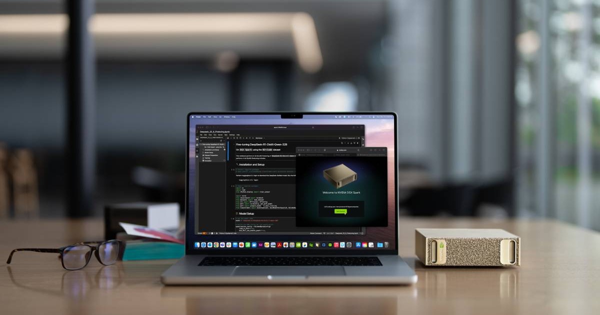 Un MacBook așezat lângă supercalculatorul NVIDIA DGX Spark, pe un bioru de culoarea lemnului.
