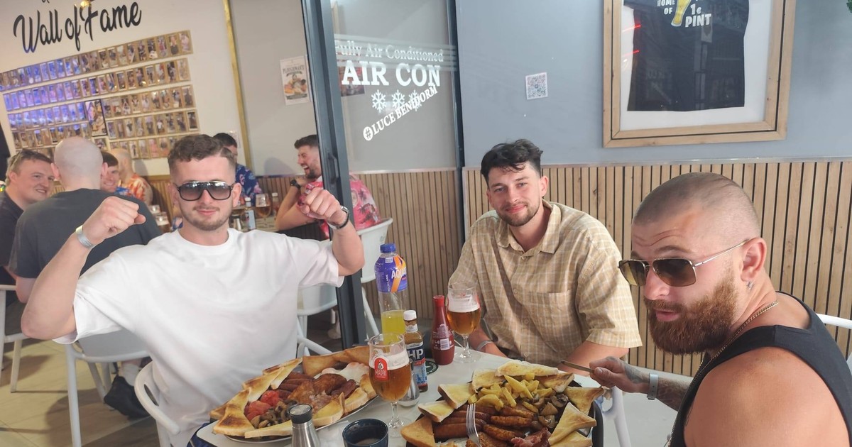 Trei bărbați mănâncă la o masă, într-un restaurant, din Benidorm