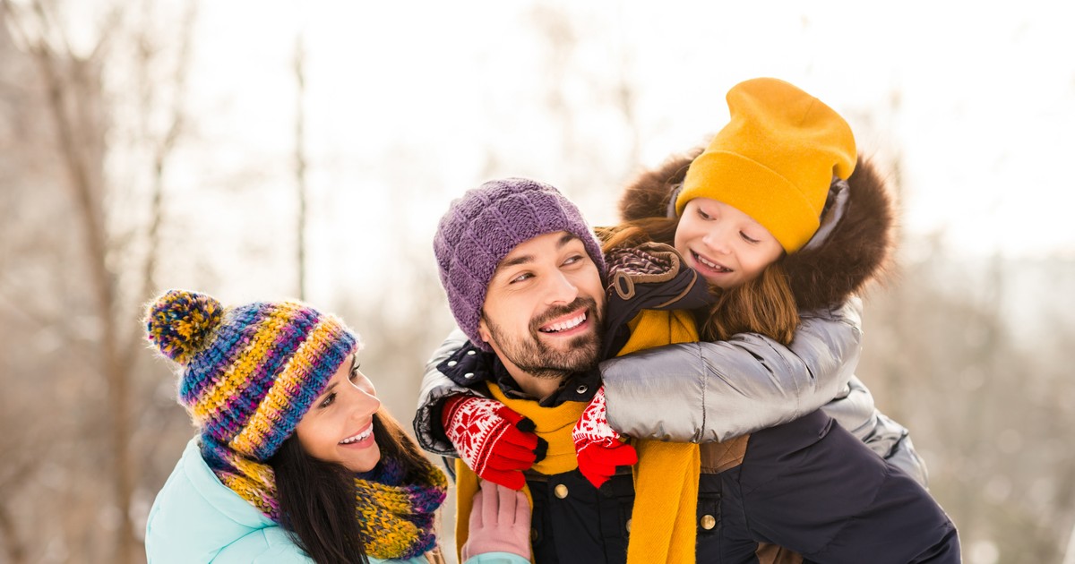 Reduceri la articole vestimentare Leviʼs în oferta Fashion Days de azi, 8 decembrie Imagine cu o tânără familie, formată din soţ, soţie şi o fetiţă, îmbrăcaţi de iarnă şi jucându-se în natură