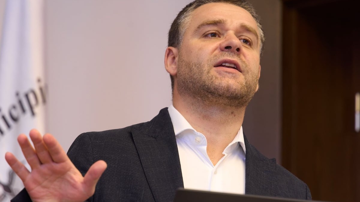 Ciprian Ciucu în costum negru în timp ce ține un discurs