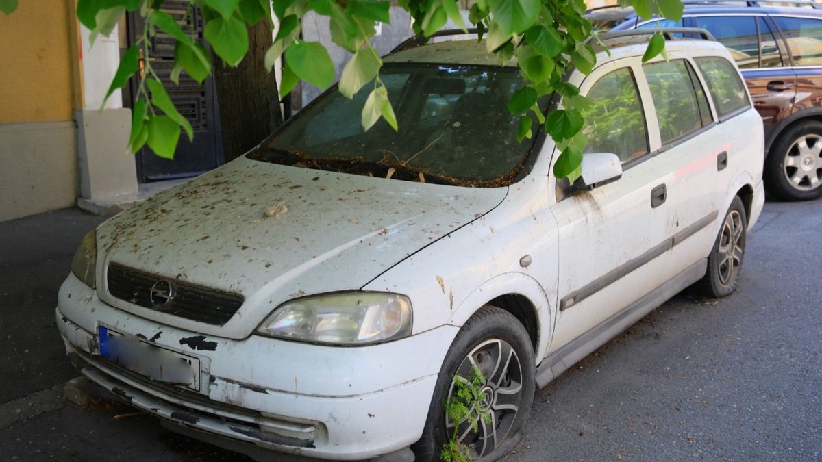 Masina cu cauciul dezumflat, parasita intr-o curte