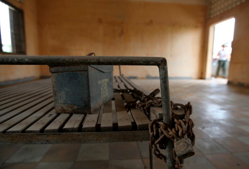 epa01637403 A tourist looks at a victim's bed with a chain and torture equipment at Tuol Sleng genocide museum where up to 14,000 people were processed to be tortured and killed in Phnom Penh, Cambodia, 16 February 2009. A UN-backed genocide court is scheduled to start trial hearings on 17 February 2009 of Kaing Guek Eav dubbed 'Comrade Duch', a former chief of the Khmer Rouge's most notorious prison Tuol Sleng (S-21). Kaing Guek Eav, who allegedly sent some 14,000 Cambodians to their deaths, is to face charges of crimes against humanity and war crimes. Around two million Cambodians died under the 1975 to 1979 Khmer Rouge regime in a failed bid by the ultra-Maoists to turn Cambodia into an agrarian utopia bereft of money, markets and social classes. EPA/RUNGROJ YONGRIT