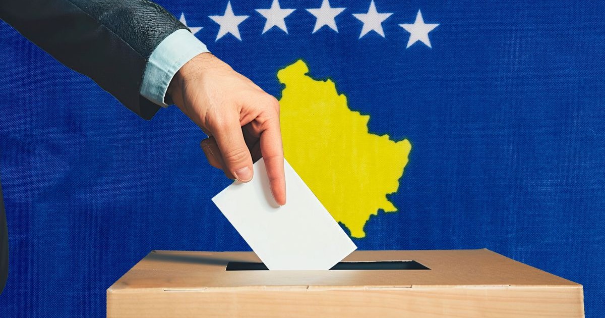 O mână ține un buletin de vot într-o urnă electorală, pe fundalul steagului Kosovo. Oamenii introduc buletinele de vot într-o urnă electorală, pe fundalul steagului Kosovo.