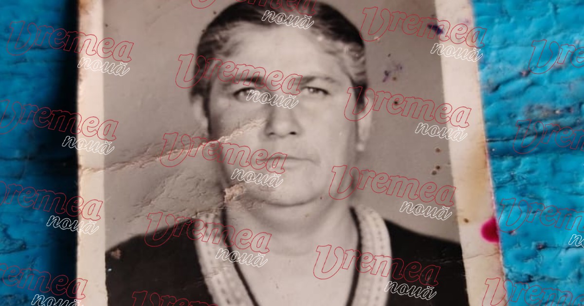 o femeie, fotografiată bust, cu părul prins la spaate și cu mîrgele la gât