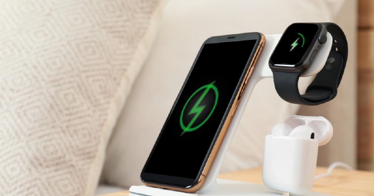 Cum funcţionează încărcarea wireless a dispozitivelor electronice - Imagine cu um încărcătpr wireless, pe care se află un telefon, un smartwatch şi o pereche de căşti audio