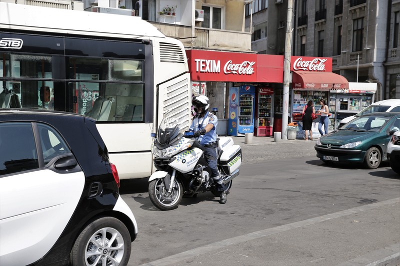 Polițist pe motocicletă, în misiunea de ridicat mașini parcate ilegal