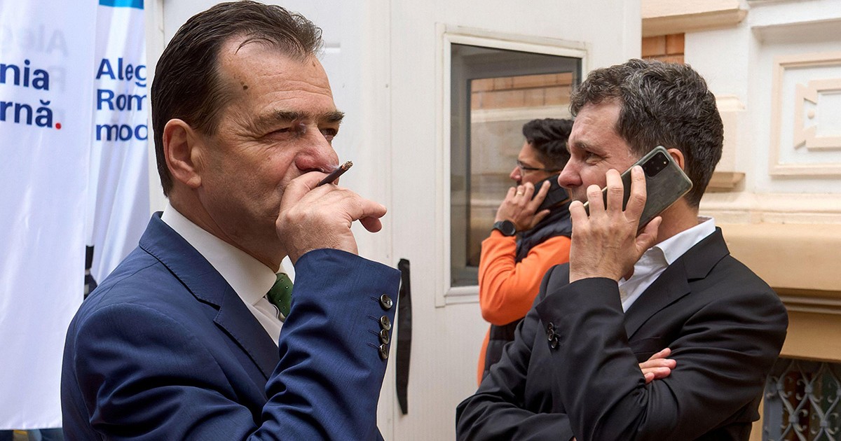 Ludovic Orban fumează o țigară și Nicușor Dan vorbește la telefon
