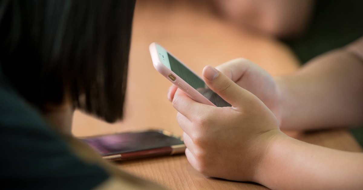 telefon tinut in mana de un adolescent