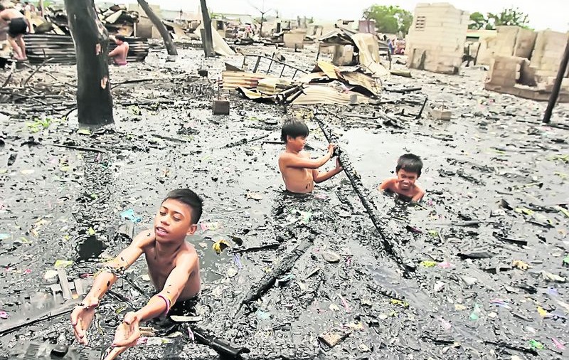 Fotografii impresionante din Filipine, după un incendiu devastator: Îşi caută lucrurile prin mocirlă 