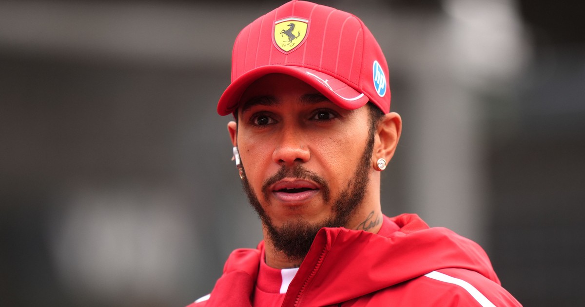 Imagine cu Lewis Hamilton purtând o șapcă roșie cu logo-ul Ferrari și o bluză de aceeași culoare